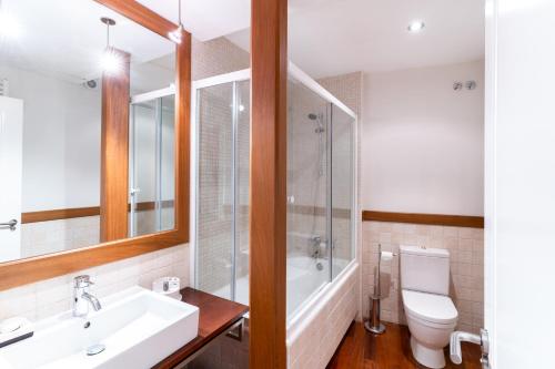 La salle de bains est pourvue d'un lavabo, d'une baignoire et de toilettes. dans l'établissement Housingleón - Galeria, à León