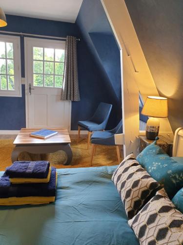 a blue room with a bed and a table at Chambre d’hôte Normande in Freneuse-sur-Risle