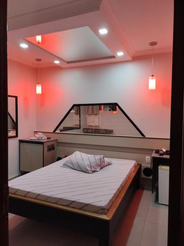 a bedroom with a bed in a room with red lights at Motel Paradise (Adults only) in São José dos Campos