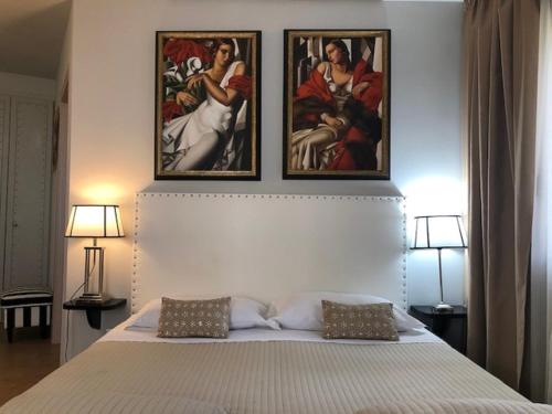 a bedroom with a bed with three paintings on the wall at Residenza Ca' degli Enzi in Verona