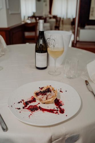 a white plate with a dessert and a bottle of wine at Hotel Niagara in Catanzaro Lido