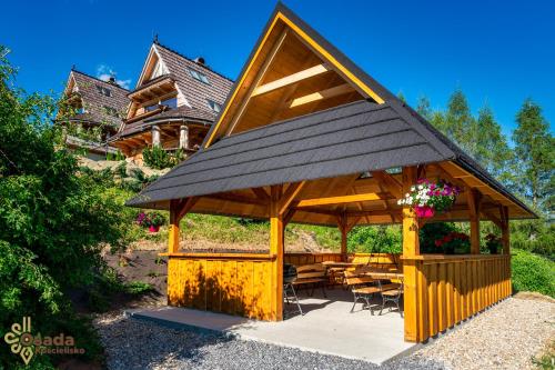a large wooden gazebo with tables and chairs at Osada Kościelisko - Tatry na Wyciągnięcie Ręki in Kościelisko