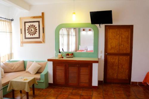 a living room with a couch and a mirror at Hotel Careyes Puerto Escondido in Puerto Escondido