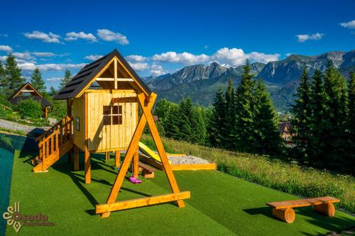 a playground with a play house and a bench at Osada Kościelisko - Tatry na Wyciągnięcie Ręki in Kościelisko