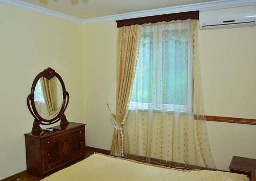 een slaapkamer met een raam met een spiegel en een dressoir bij Getap Restaurant & Hotel Vahagnadzor in Vahagnadzor