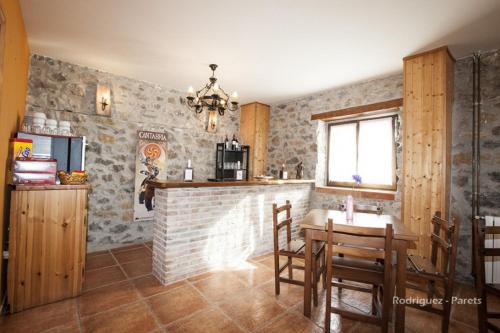 a kitchen with a brick fireplace and a table and chairs at El Pradón in Mar