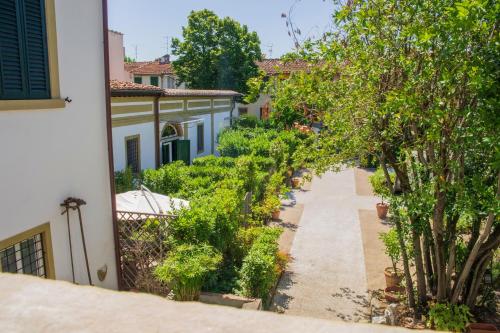an alley between two buildings with trees and bushes at L'OZioRinco Apartments in Florence