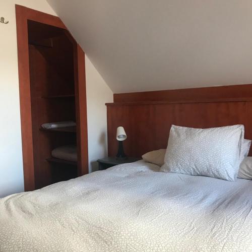 a bed with a wooden headboard and a white pillow at Stort hus med 4 sovrum in Käglinge