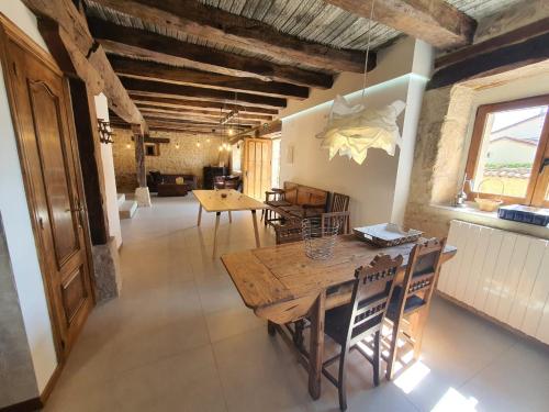 ein Esszimmer mit einem Holztisch und Stühlen in der Unterkunft CASA RURAL PALACIO LOS LABREQUINES in Villacomparada de Rueda