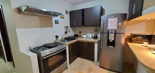 a small kitchen with a stove and a refrigerator at NCG Suite in Guayaquil