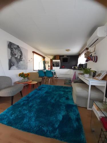 uma sala de estar com um tapete azul no chão em kitty"s Chalet Modern en toch knus em Warmond