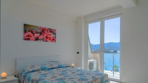 a bedroom with a bed and a large window at Appartamento Fronte Mare Bilocale in Portoferraio