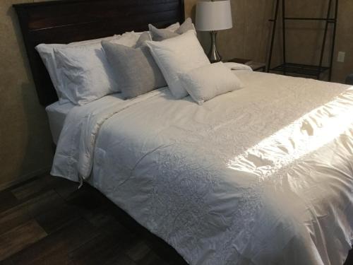 a large white bed with white pillows on it at Kickapoo Shores Waterfront Cottages in Onalaska