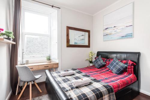una camera con letto, scrivania e finestra di City Centre Stylish Apartment at The Meadows Park a Edimburgo