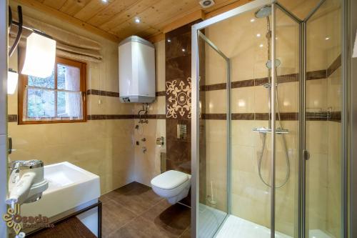 a bathroom with a shower and a sink and a toilet at Osada Kościelisko - Tatry na Wyciągnięcie Ręki in Kościelisko