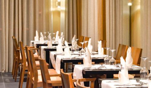 a group of tables with white table cloths on them at Hotel Solar Bom Jesus in Santa Cruz