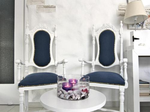 a room with two blue chairs and a table with candles at Hotel Opera in Larnaca