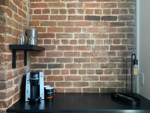 a brick wall with a coffee maker on a table at Hotel Le Saint-Paul in Quebec City