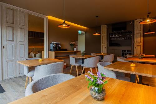 a restaurant with wooden tables and chairs and flowers at Quinta do Pedregal Hotel & Spa in Vila Nova de Gaia