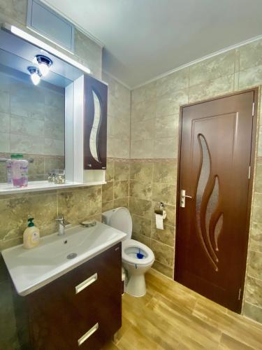 a bathroom with a sink and a toilet and a door at Apartament Sunshine in Orşova