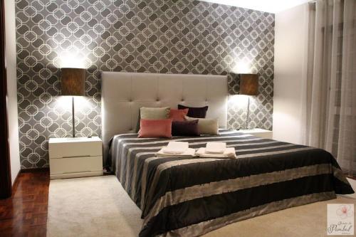 a bedroom with a large bed with two lamps at Quinta do Pombal Douro in Penajoia