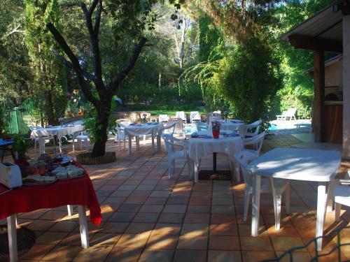 a group of white tables and chairs on a patio at Les Chambres d'Hotes au Bois Fleuri in Roquebrune-sur-Argens