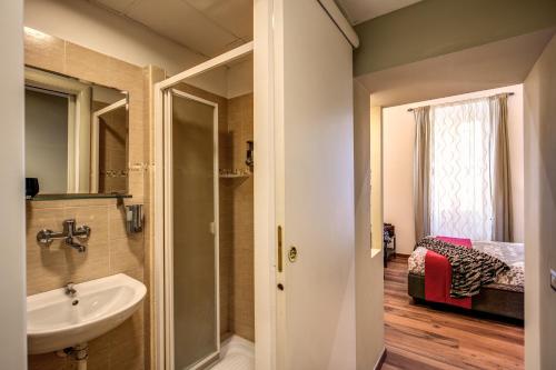 a bathroom with a sink and a bedroom at Monticello apartment via Cavour in Rome
