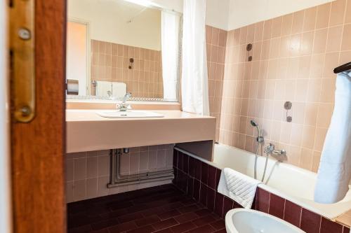 une salle de bain avec un lavabo, des toilettes et un miroir dans l'établissement Hotel du Port, à Canet