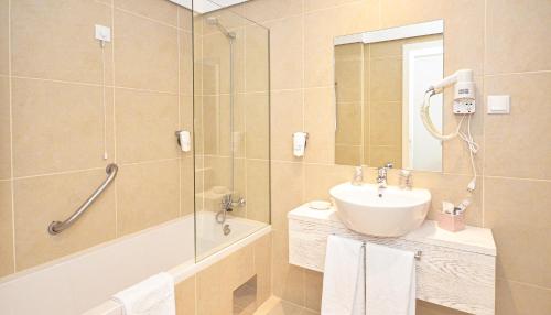 a bathroom with a shower and a sink and a mirror at Hotel Solar Bom Jesus in Santa Cruz