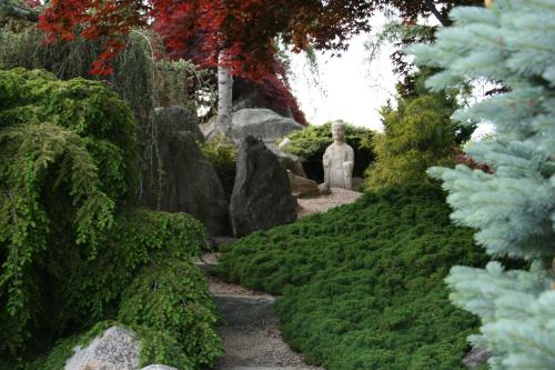 a garden with a statue and some green plants at Pleasant Bay Village Resort in Chatham