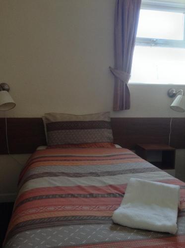 a small bedroom with a bed with a window at The Premier Lodge in Morpeth