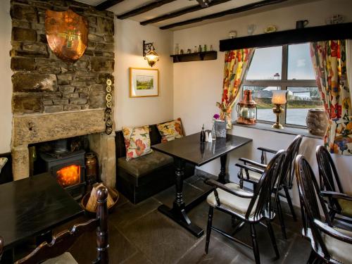 een eetkamer met een tafel en een open haard bij The Barrel Inn in Eyam