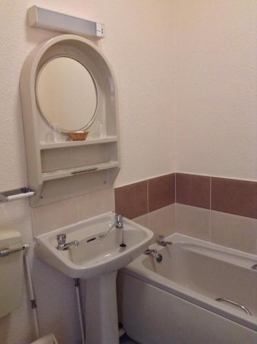 a bathroom with a sink and a mirror and a tub at The Premier Lodge in Morpeth
