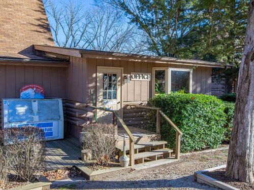 a small house with a porch and a staircase at Bar M Resort & Campground in Branson West
