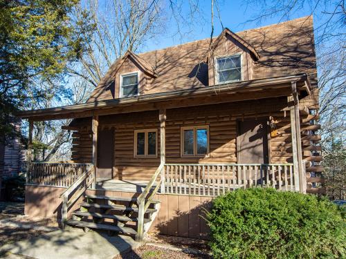 a log cabin with a porch and a house at Bar M Resort & Campground in Branson West