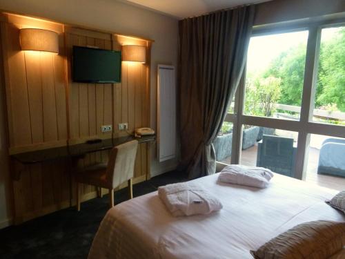 a hotel room with a bed and a window at Bastide du Cantal in Salers