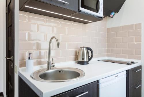 a kitchen with a sink and a microwave at Khreshchatyk - Independence Square Apartments in Kyiv