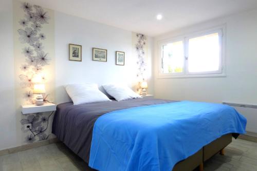 sypialnia z dużym łóżkiem i niebieskim kocem w obiekcie Gites Bel Air de Rosette w mieście Bergerac