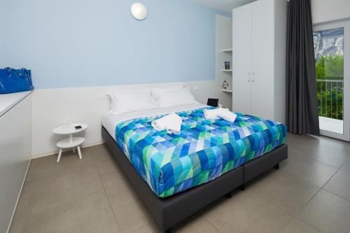 a bedroom with a bed with a colorful bedspread at Appartamenti Villa al Fiume in Nago-Torbole
