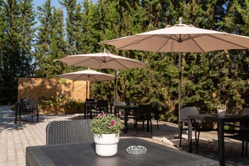 a patio with tables and chairs with umbrellas at Manta Guest - Bed & Breakfast in Manta Rota