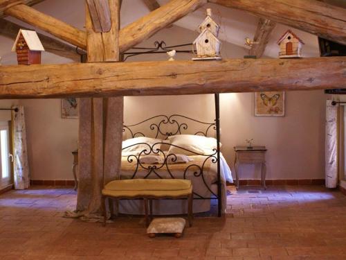 een slaapkamer met een bed met een houten bedframe bij Maison Bersane in Le Poujol-sur-Orb