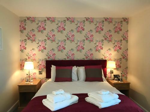 a bedroom with a bed with two towels on it at The Bird in Hand in Ashwellthorpe