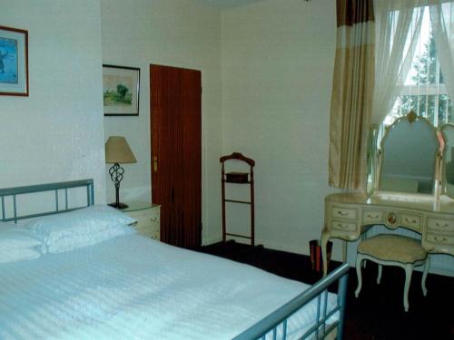 a bedroom with a bed and a desk and a mirror at BlackbullA1lodge in Grantham