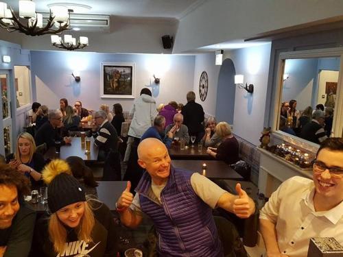 um grupo de pessoas sentadas em um restaurante dando polegares para cima em The Blackbull Inn Polmont em Polmont