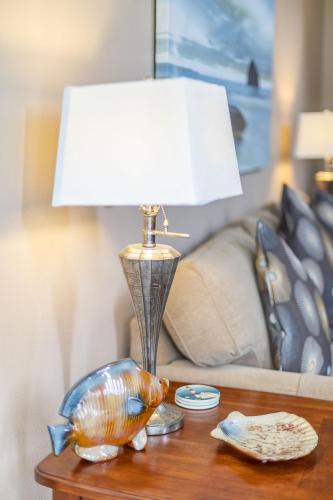 a table with a lamp and a fish bowl on it at Gaea House in Seaside