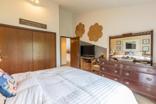 a bedroom with a large bed with a dresser and a mirror at Gaea House in Seaside
