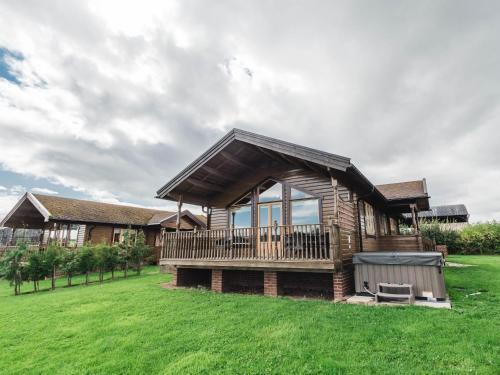 a log home with a large yard with a grassy field at Blackthorn Gate in Nunthorpe
