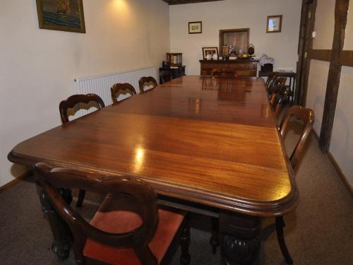 a large wooden table with chairs around it at Bluebell Farm in Upton upon Severn