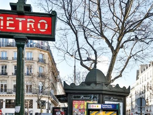 a sign on a pole in a city with buildings at Blue Nights Sébastopol 110 in Paris