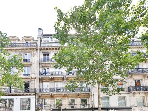 een gebouw met een boom ervoor bij Blue Nights Sébastopol 110 in Parijs